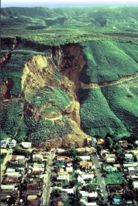 Source: USGS, Public Domain Image shows distinct scarp and slide material covering several houses.