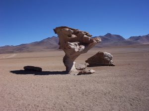 Large rock standing on a base narrowed by sandblasting.