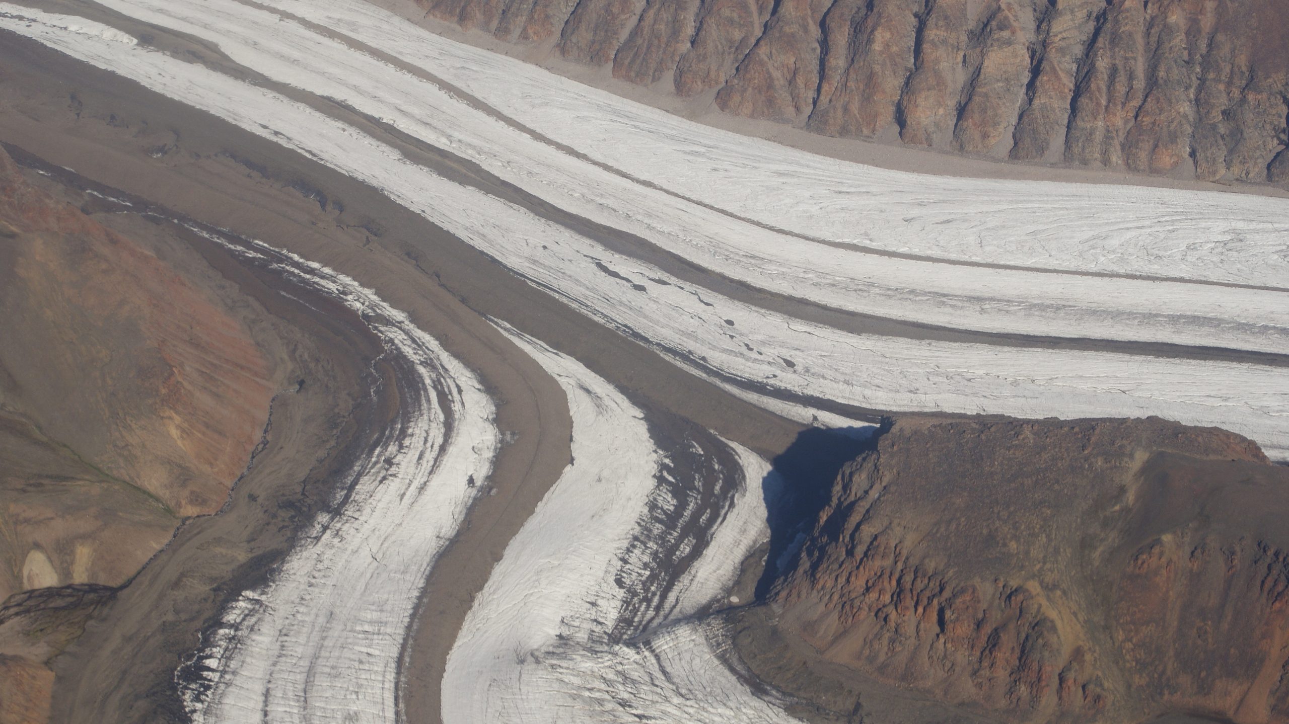 Thick lines of sediment in the middle of the glacial ice.