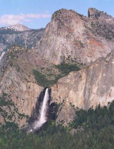 U-shaped valley feeding into another, lower u-shaped valley. A waterfall forms where the higher valley meet the lower valley.