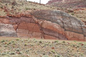 Roadcut outcrop of multicolor rock beds offset by a normal fault.