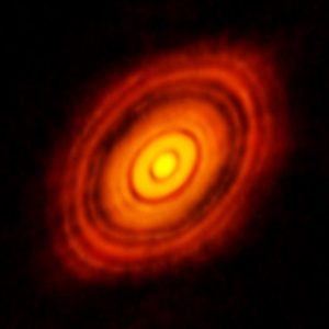 "By The orange disk has zones that are darker, indicating the planets are growing by using that material in the disk.