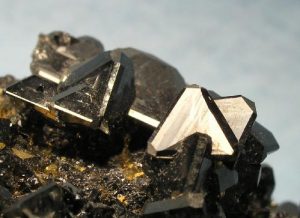 The dark brown mineral is triangular