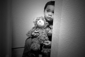 young child holding teddy bear