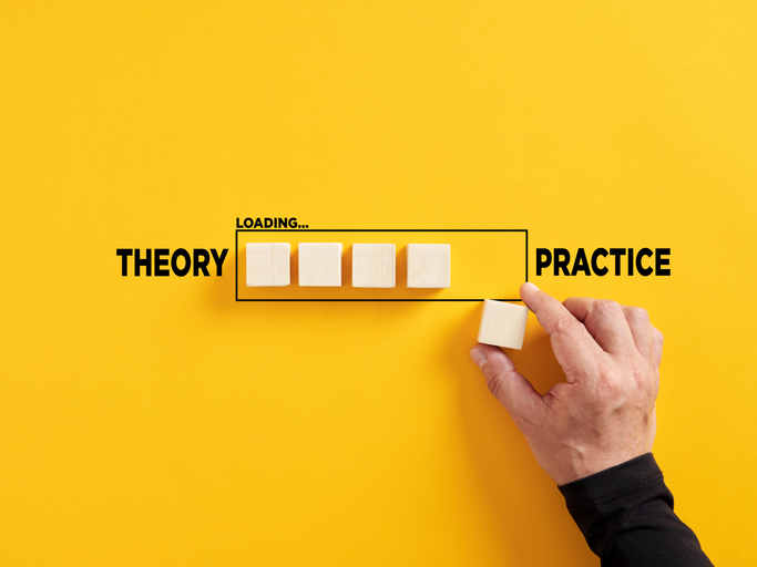 Transition of theory into practice. Implementation of theories in practice. Hand places a wooden cube to the loading bar with the words theory and practice