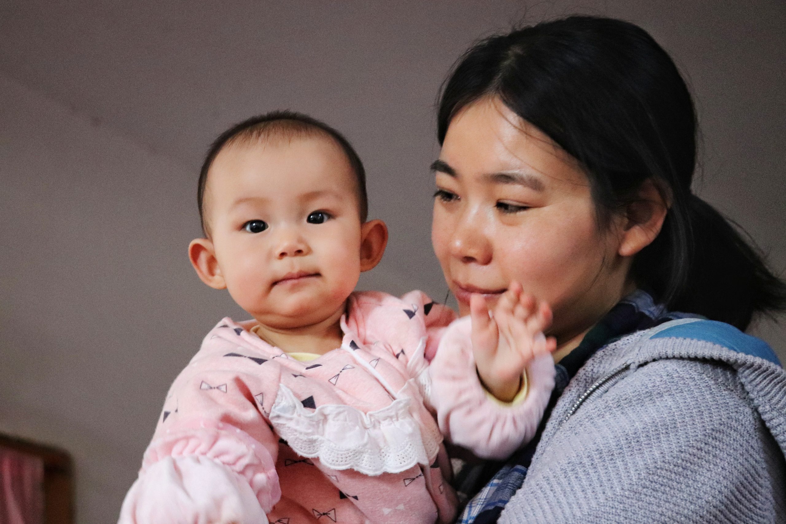 Image shows a photo of a mother holding her baby girl.