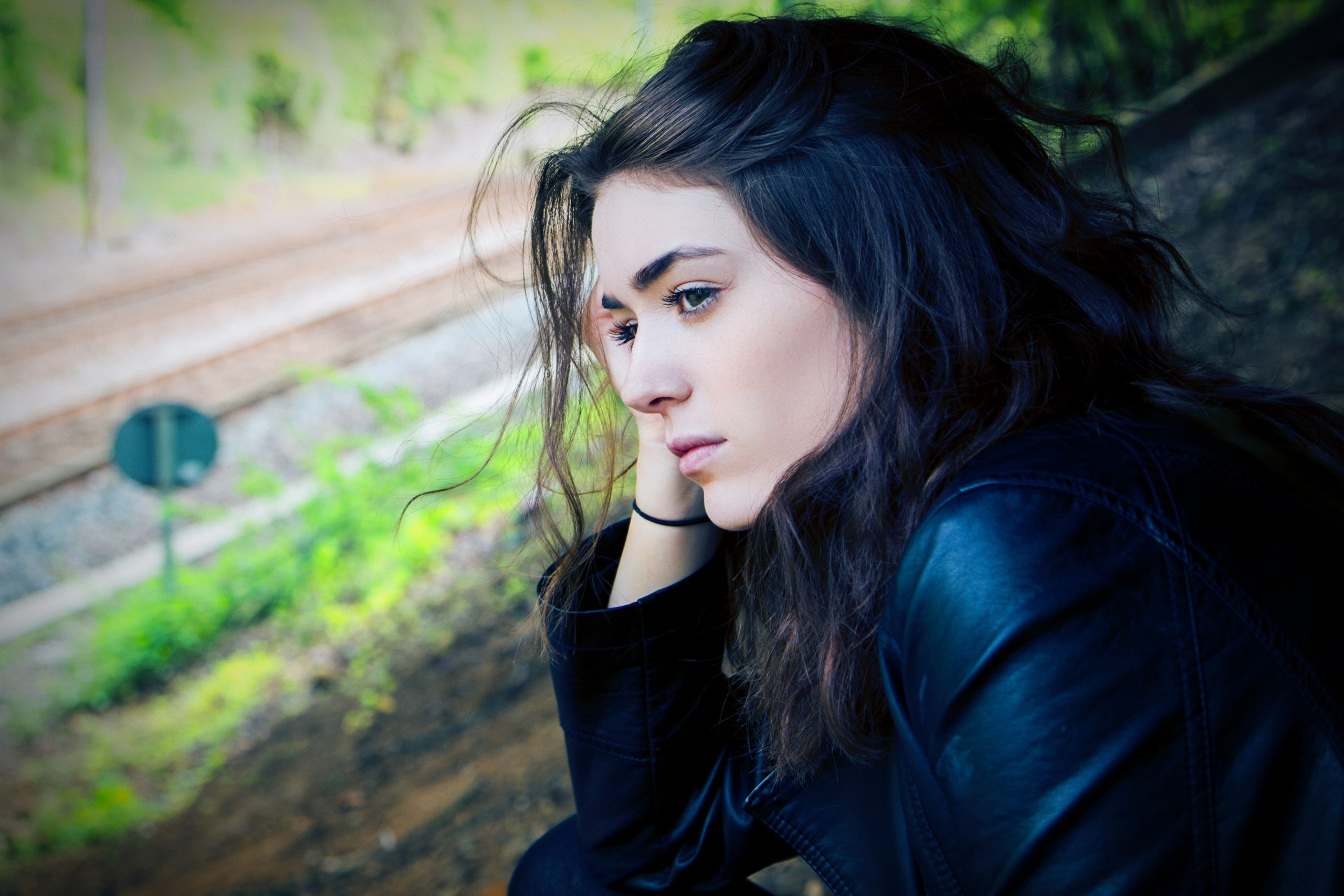 In this image, a woman looks thoughtfully out at the countryside.