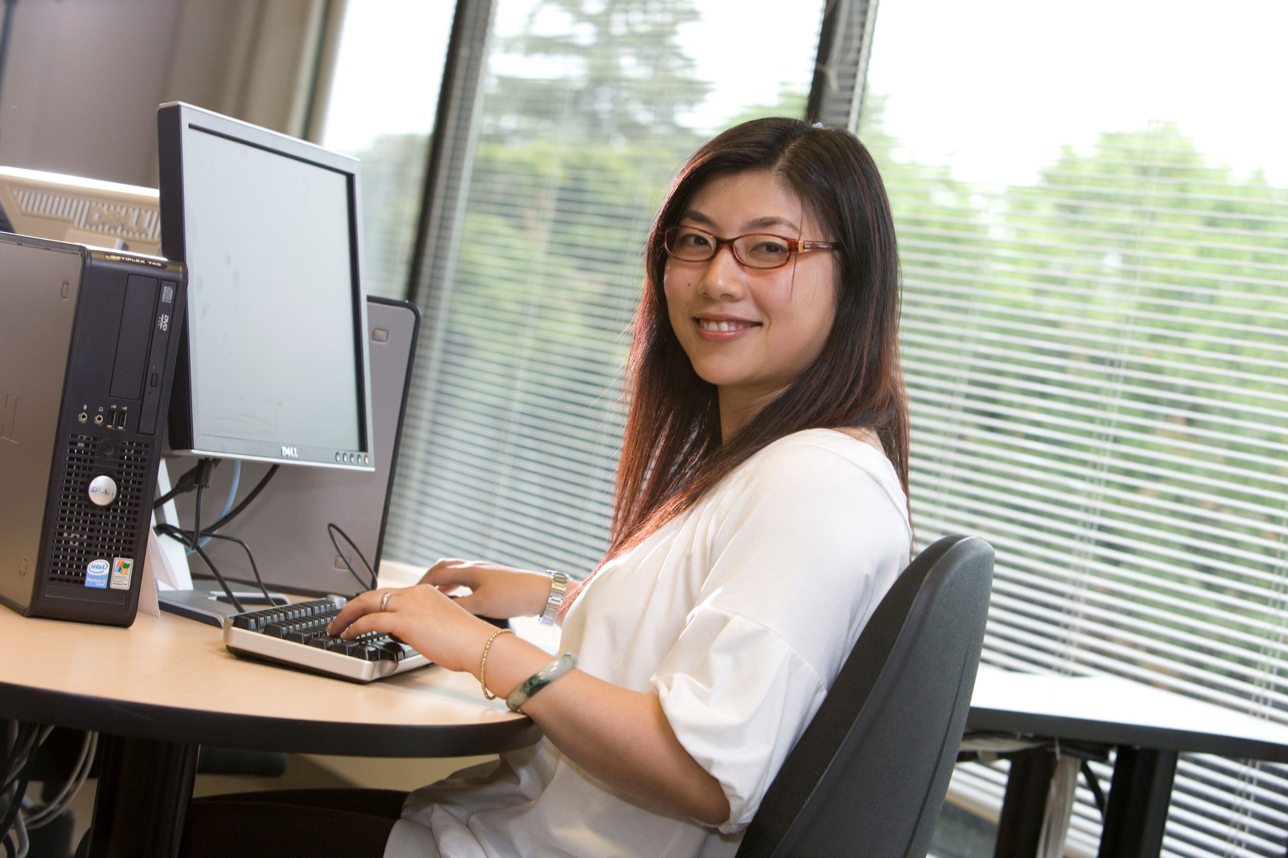“Woman_with_computer.jpg” by Cumminsr at English Wikipedia is licensed under CC BY-SA 3.0 Photo showing a simulated graduate taking a test at a computer