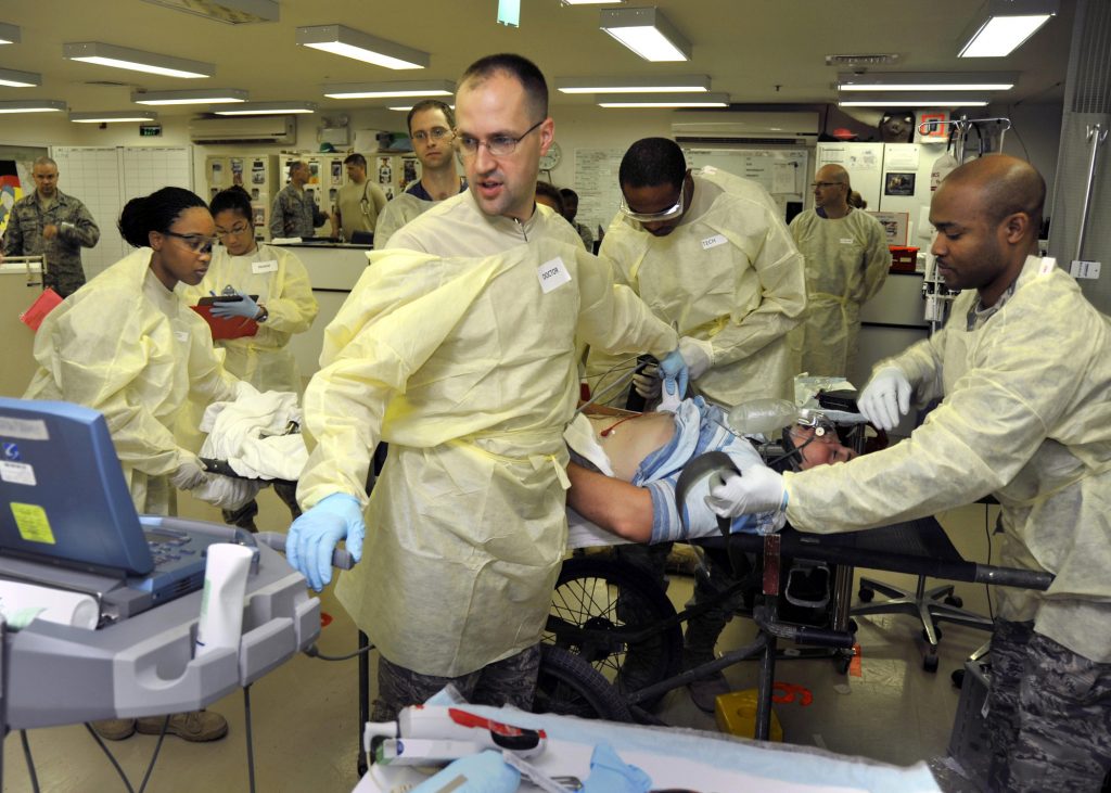 “Emergency_medicine_simulation_training_exercise_in_Balad%2C_Iraq.jpg” by Robert Couse-Baker is licensed under CC BY 2.0 Photo showing medical personnel in a stressful health care enivronment