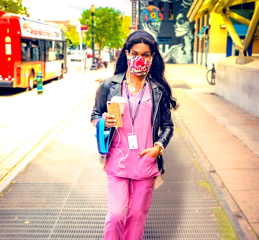 “49855067292_d521d20931_o-e1626806176568.jpg” by Ted Eytan is licensed under CC BY-SA 4.0 Photo showing a masked nurse walking down a city sidewalk