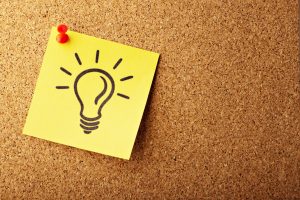 A lightbulb drawn on a sticky note pinned to a board