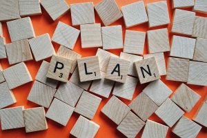 The word 'plan' spelt out in scrabble pieces