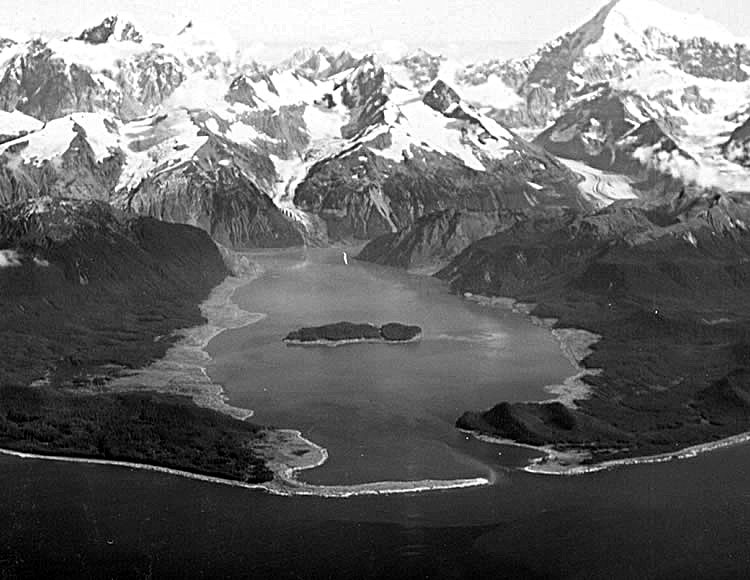 Photograph of Lituya Bay taken a few weeks after the 1958 megatsunami. The rockslide occurred in the mountains at the head of the bay, producing the wave that them moved through the bay towards the sea