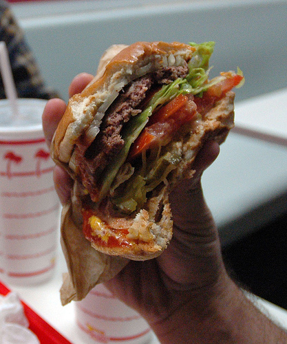 Image of someone holding an In and Out burger they are eating