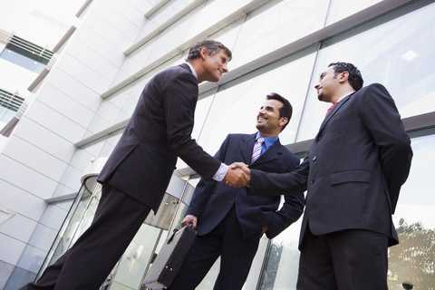 Businessmen talk and shake hands.