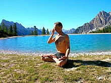 A man practices yoga meditation outside.