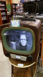 An antique television displays an episode of The Munsters, a 1960s sitcom.