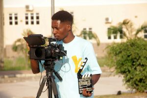 Young man operating a professional video camera