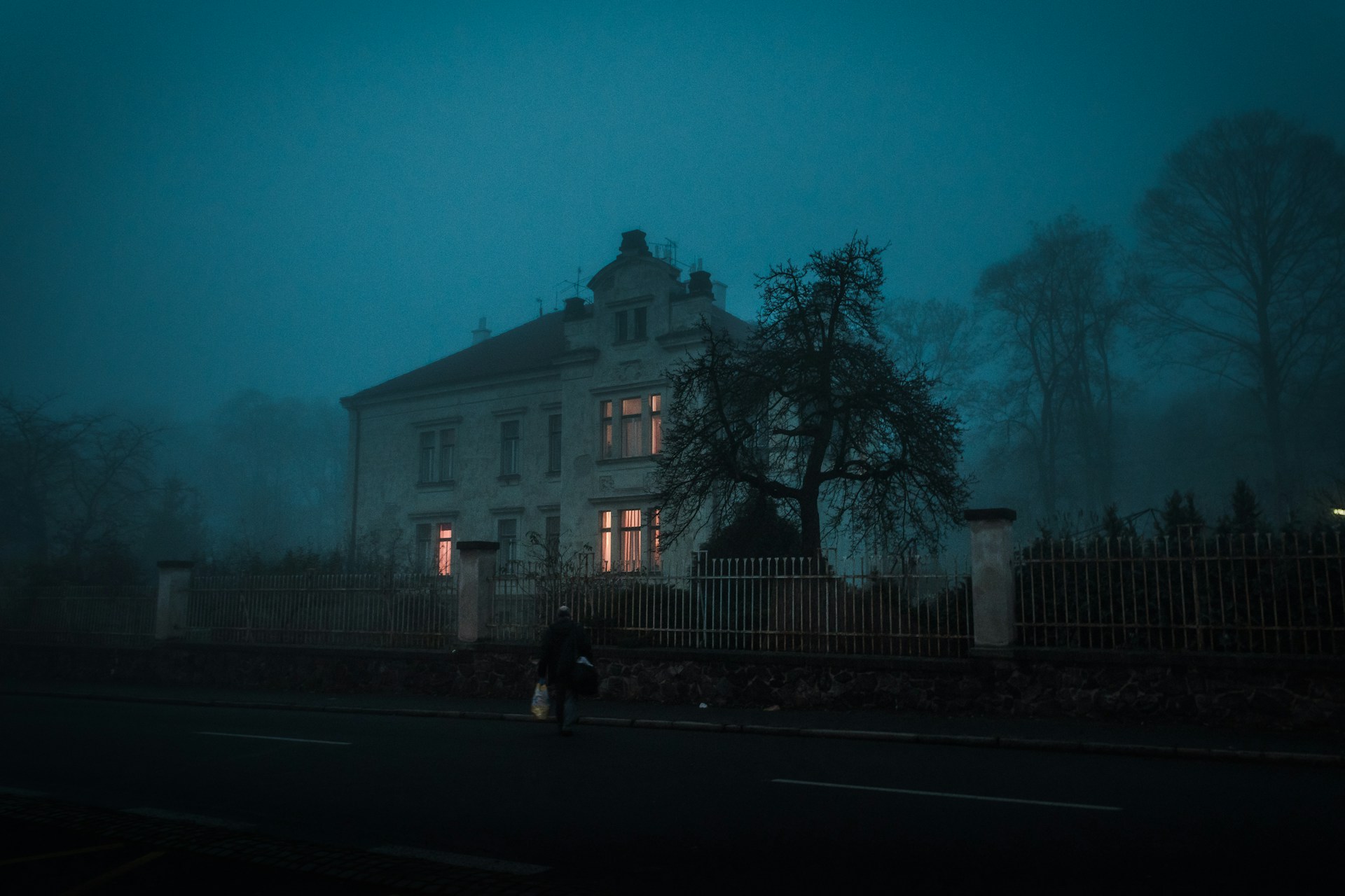 Man walking toward spooky house at night