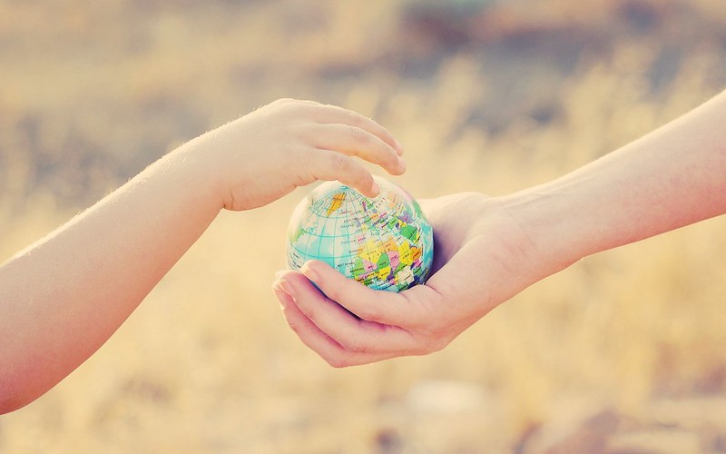 Hands holding globe.