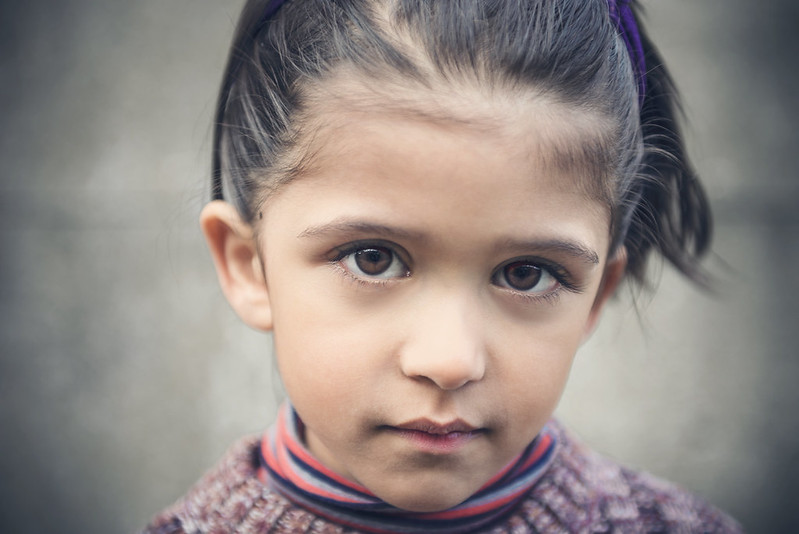 Girl with brown hair and brown eyes looking at camera.
