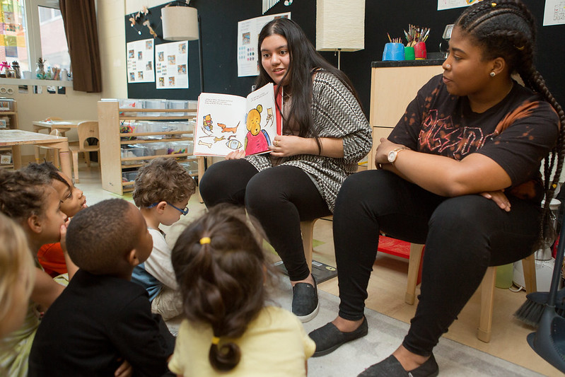 Student teachers reading to preschool students.