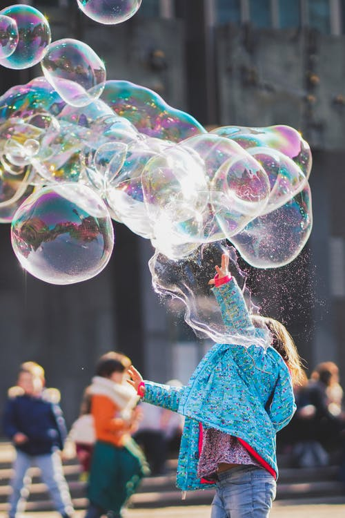 Girl playing with large bubbles.