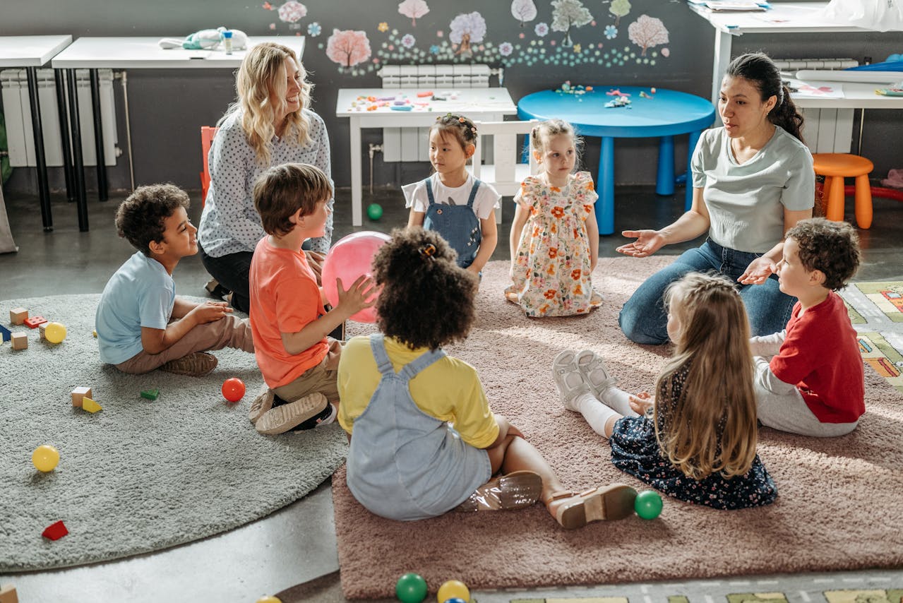 Preschool students and teachers sitting in a circle in the classroom.