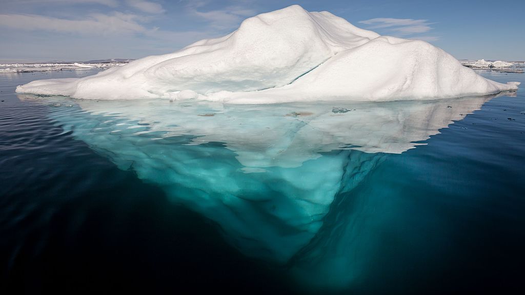 Image of entire iceberg above and below water.