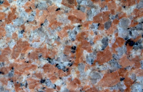 Close up granite rock with colors of while, black, and rust.