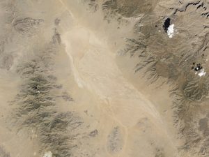 Satellite image of desert playa surrounded by mountains.