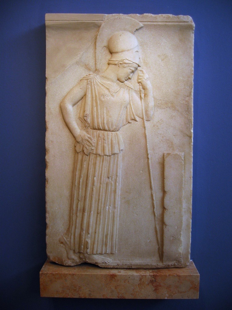 A bas relief of Athena leaning mournfully on her spear. She wears a helmet as if returning from war.