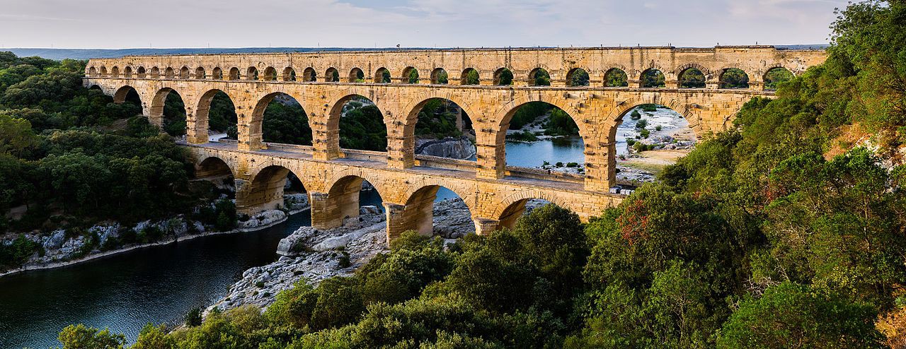 Three level aqueduct with increasingly smaller arches on the second and third levels. The aqueduct also serves as a bridge over a river.