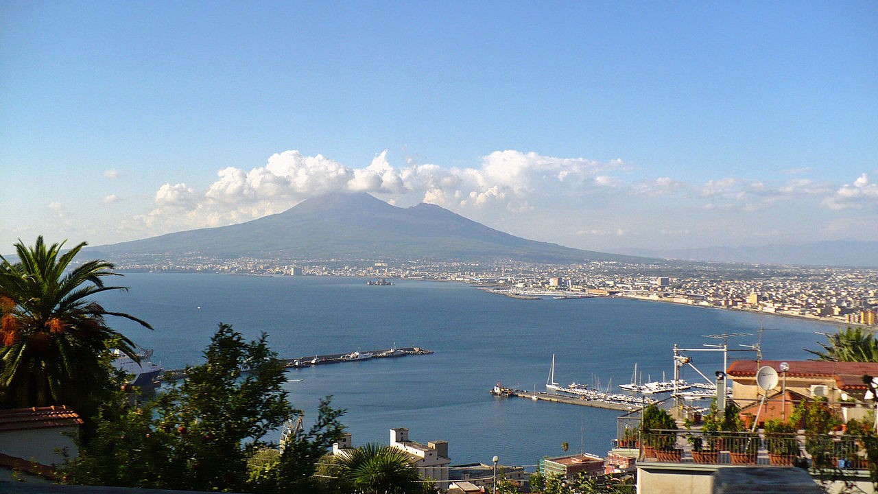 Mount Vesuvius seen from across the bay with the city in front of it.