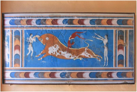 Fresco of huge bull with a man leaping over it. One companion holds it by the horn and another companion stands behind the bull, perhaps having helped the leaping man to gain altitude.