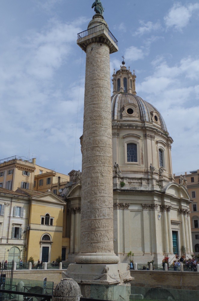A carved Roman column in front of a building from later centuries. Refer to the text for details.