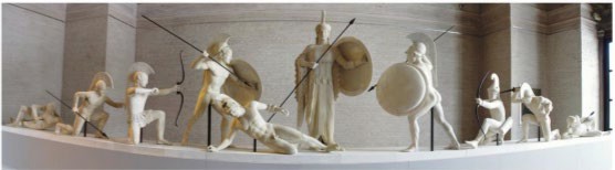 A reconstruction of a pediment scene. Athena stands in the center and warriors fight and fall around her.