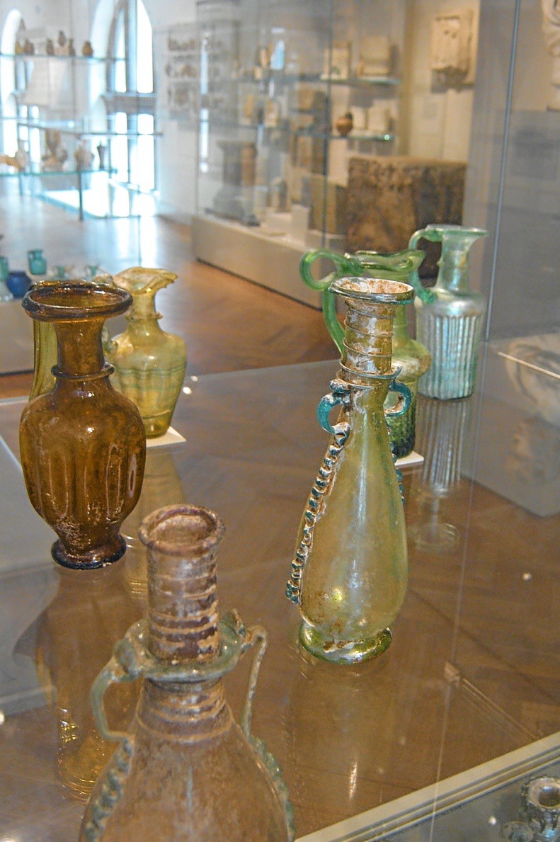 A photo of a table covered with glass bottles of different shapes and colors.