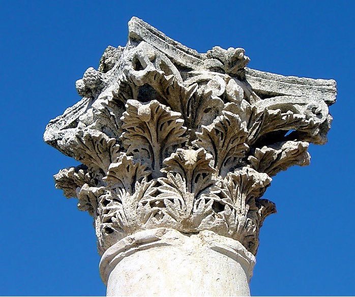 A photo of a Corinthian capital. It is elaborately carved with acanthus leaves.