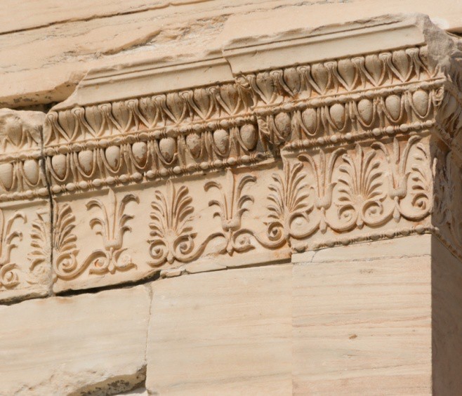 Photo of the entablature, which is covered with stylized foliage designs, topped with egg and dart shapes.