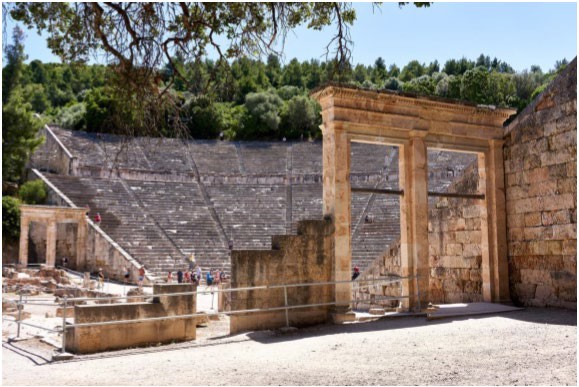 A view of the theatron seen through and around the doorways of the parados on one side of a theater.