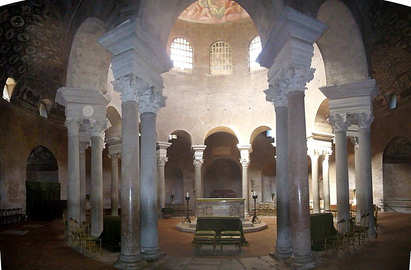 The interior of the building with light streaming in from clerestory windows. An altar has been placed in the center under the dome.