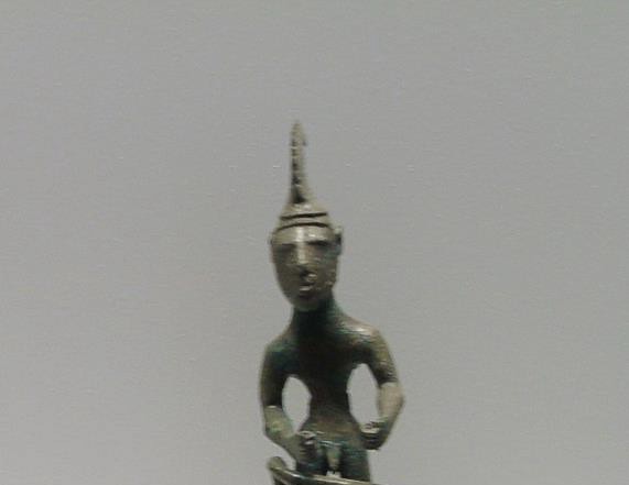 Bronze figure with simplified features and helmet.
