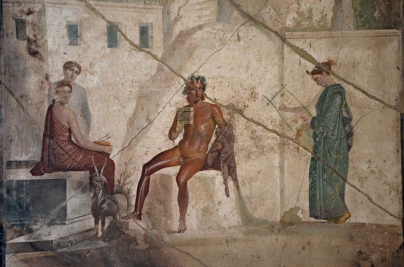A wall painting of a naked, horned young man seated and holding a flute. He is surrounded by women and a goat.