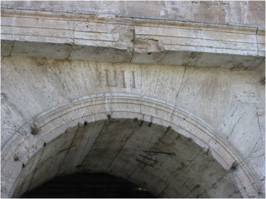 An entrance arch numbered 52 in carved Roman numerals.