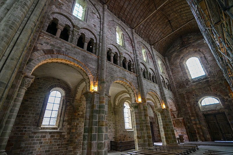 An interior shot of a church built with round arches and stone walls.