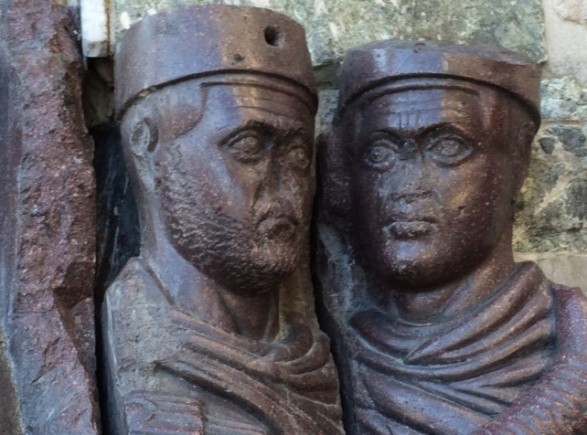 A close-up of the bearded figures crowned with simple headdresses.
