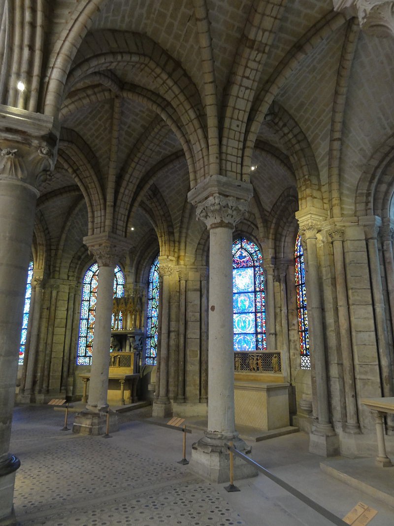 The decorative ambulatory of St. Denis. Ribbed arches and stained-glass windows distinguish it from Romanesque churches.