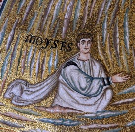 A robed man is seen with the top half of his body above clouds in the sky.