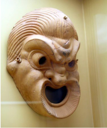 A terra cotta clay copy of a theatre mask.